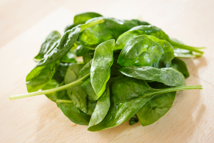 A bunch of spinach on a wooden table