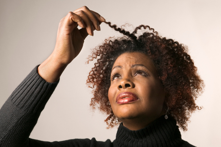 woman looking at her hair