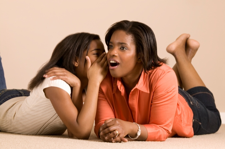 Girl telling lady a secret