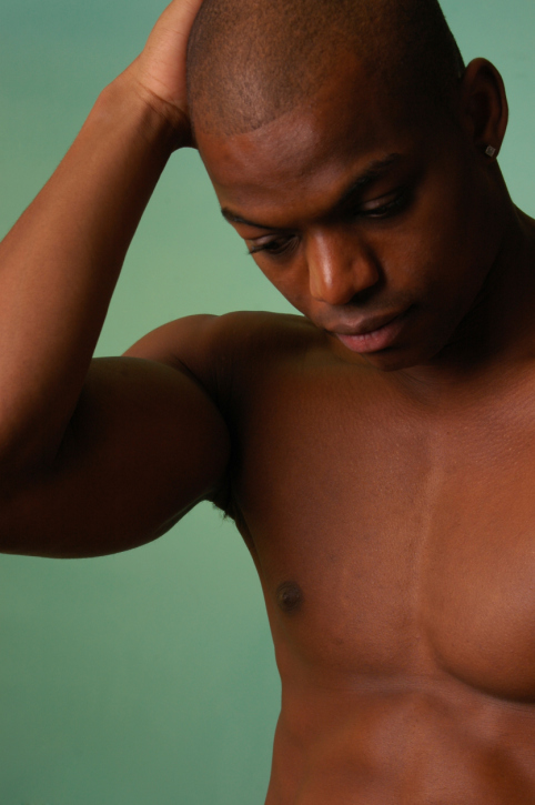 african american male on aqua background with his hands to his head.