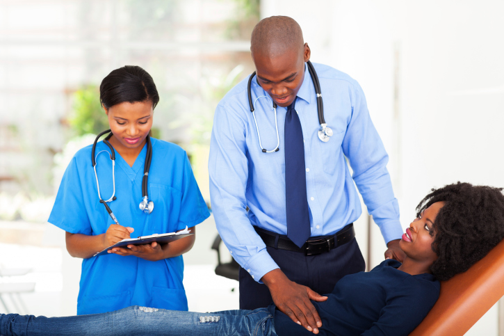 african doctor examining female patient