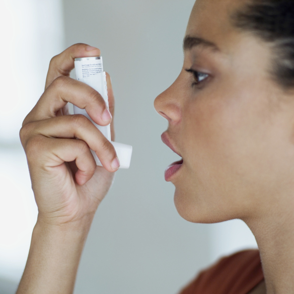 side profile of woman about to use an inhaler