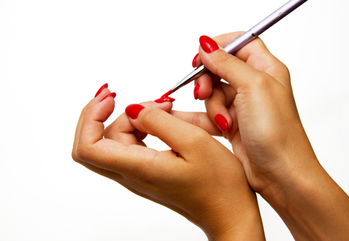African American Black hands painting nails red
