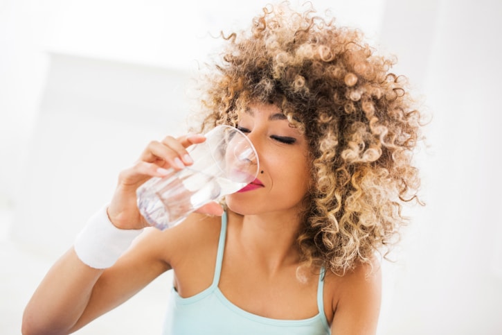 African American Black woman drinking water