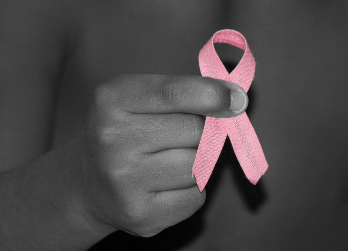 hand holding breast cancer ribbon