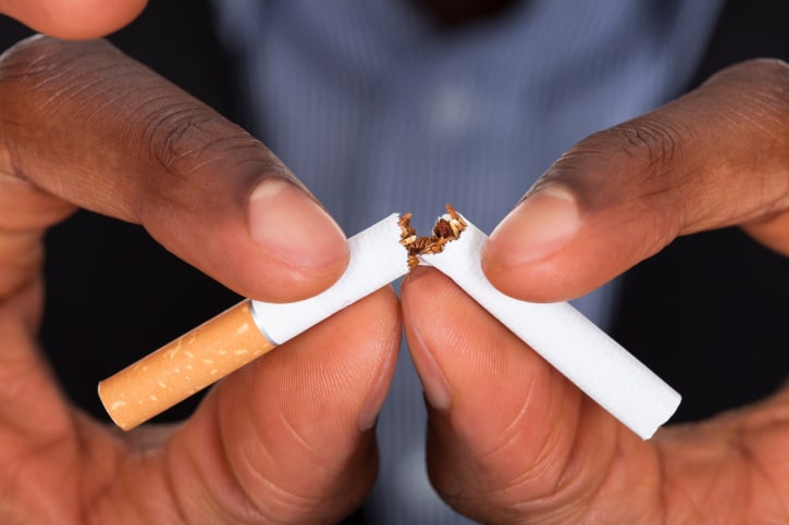 African American man hands breaking cigarette
