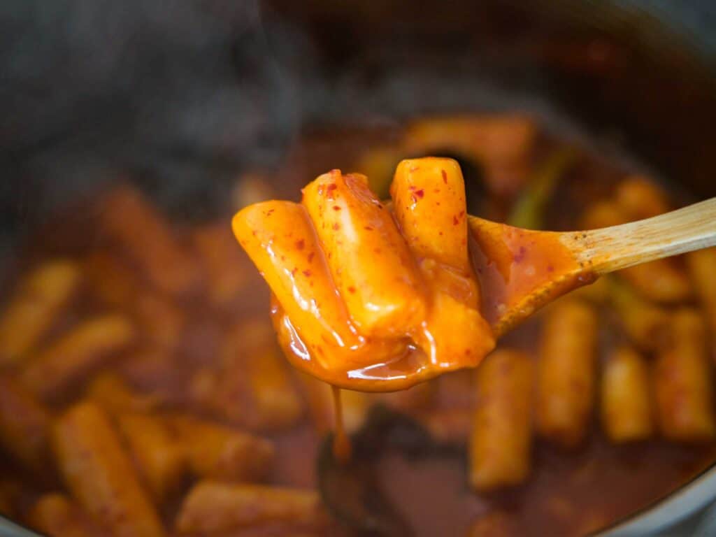 15-Minute EASY Vegan Tteokbokki - Spicy Korean Rice Cakes. 3 3 pieces of spicy vegan tteokbokki in a spoon