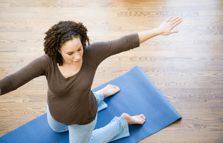 Pregnant African woman practicing yoga