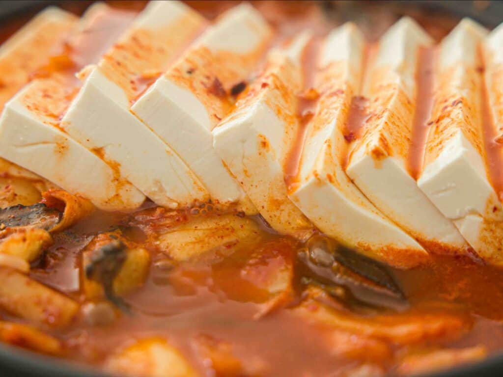 Easy & Hi-Protein Vegan Kimchi Jjigae Reigns Supreme. 14 Close up shot of tofu in vegan kimchi jjigae