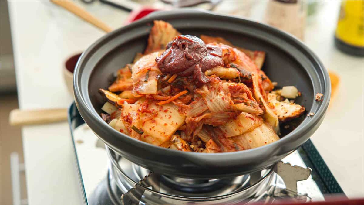 Easy & Hi-Protein Vegan Kimchi Jjigae Reigns Supreme. 12 kimchi gochujang and vegetables prepped for kimchi jjigae in pot