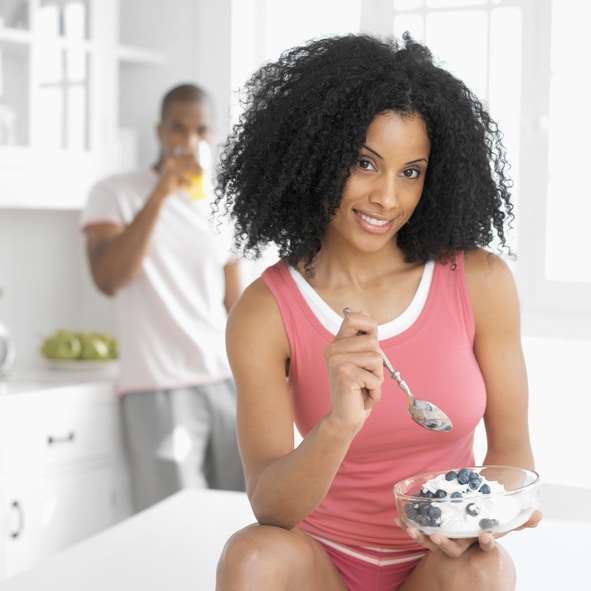 African American woman eating yogurt
