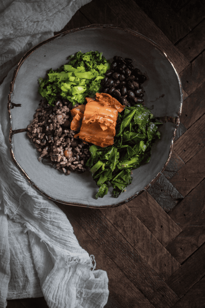 The Notorious “RBG”: Rice, Beans, and Greens 2 beans, rice, broccoli and collard greens together on white plate with gold trim