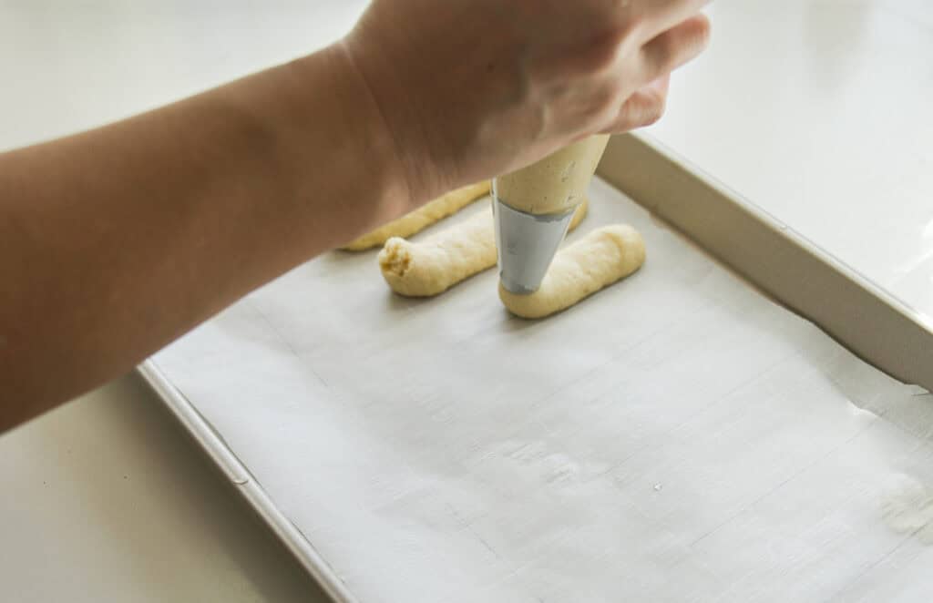 Dreamy Homemade Vegan Tiramisu Recipe (Easy & Delicious) 9 piping ladyfinger dough onto baking sheet with parchment paper