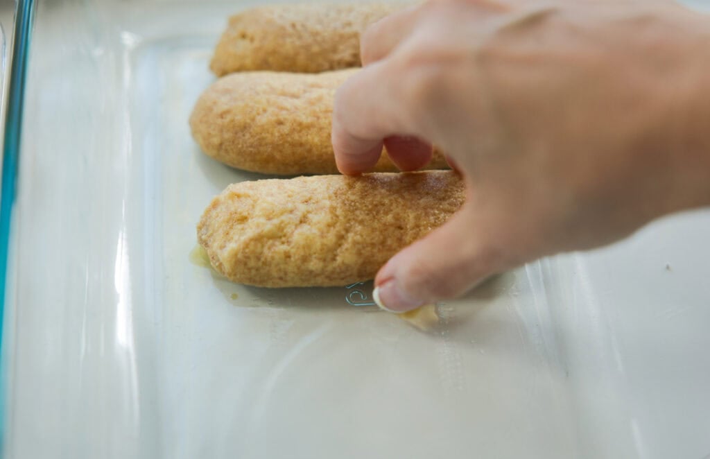 Dreamy Homemade Vegan Tiramisu Recipe (Easy & Delicious) 14 placing soaked ladyfingers in the casserole dish