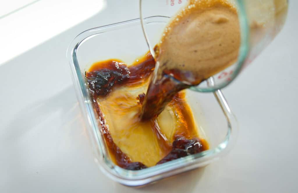 Super Easy and DELICIOUS Vegan Biscoff-Misu Recipe. 13 Pouring espresso syrup into glass container