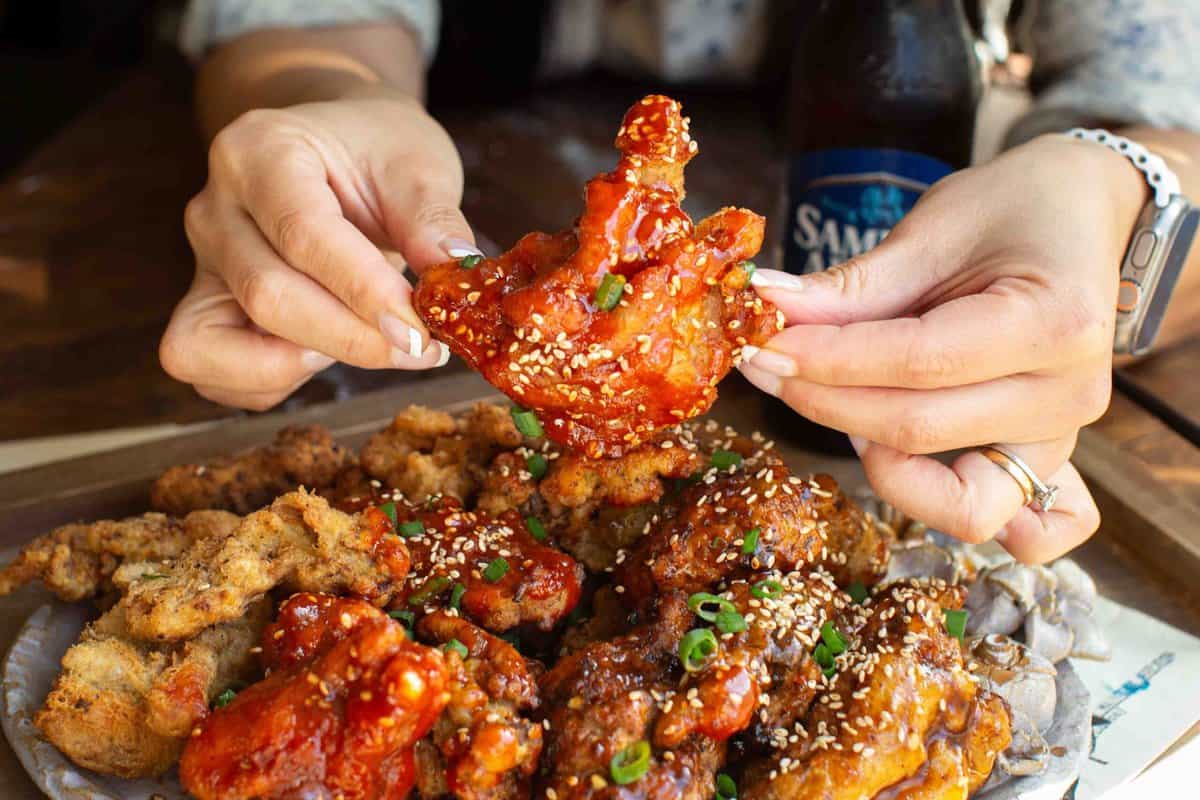 holding-vegan-fried-chicken-with-spicy-sauce