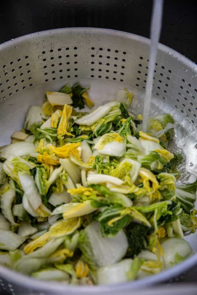 The BEST Vegan Kimchi (김치) Recipe (Easy & Homemade). 9 Cabbage leaves being rinsed.