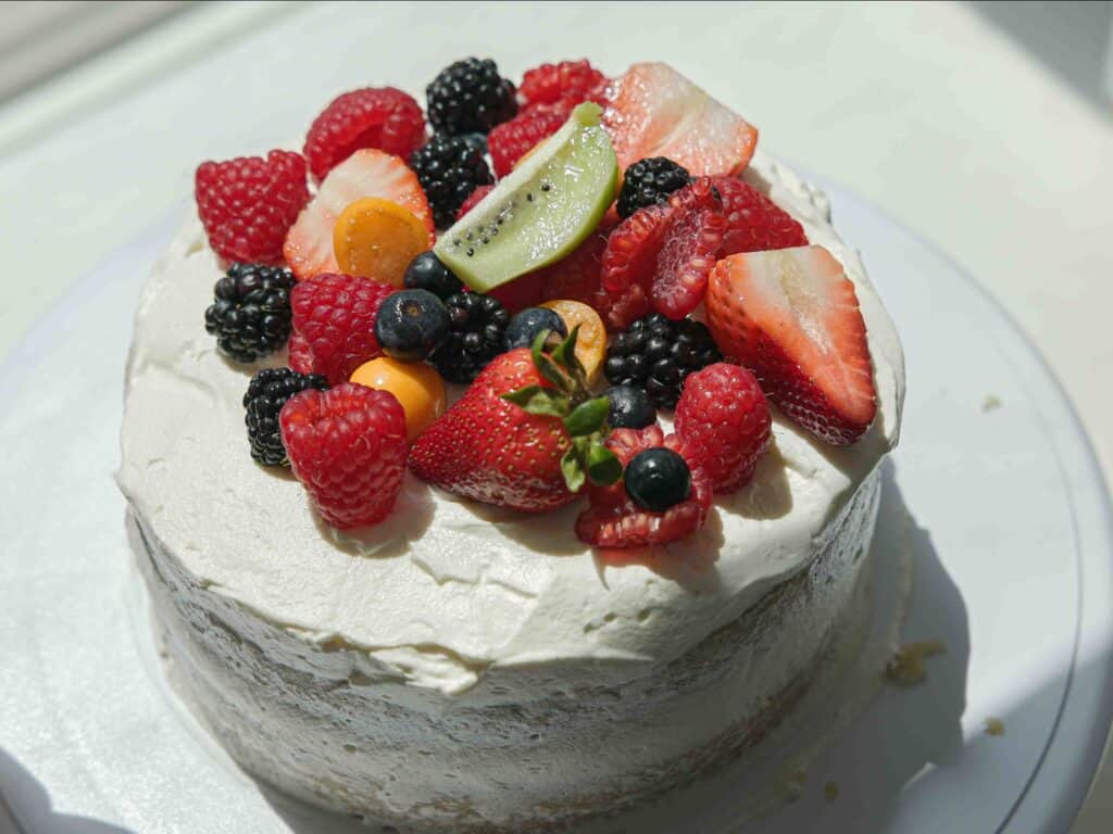 The Perfect NO BAKE Easy Vegan Sponge Cake Recipe. 3 Decorated sponge cake with fruit and whipped cream