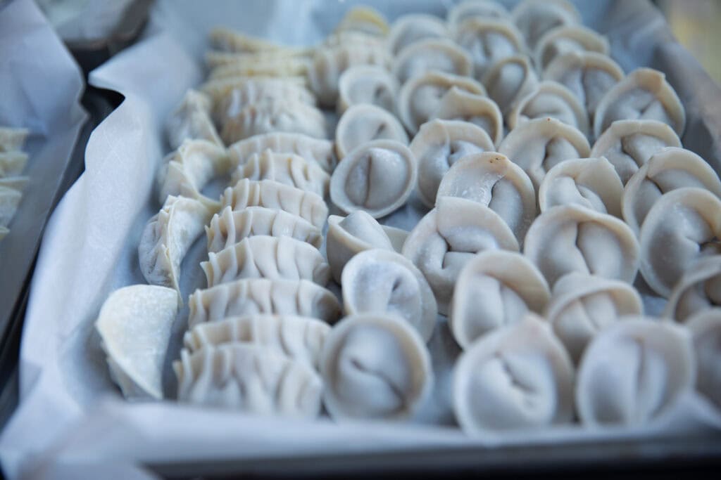 Homemade Vegan Dumplings Recipe - Kimchi Mandu. 2 columns of folded uncooked dumplings for vegan dumplings recipe