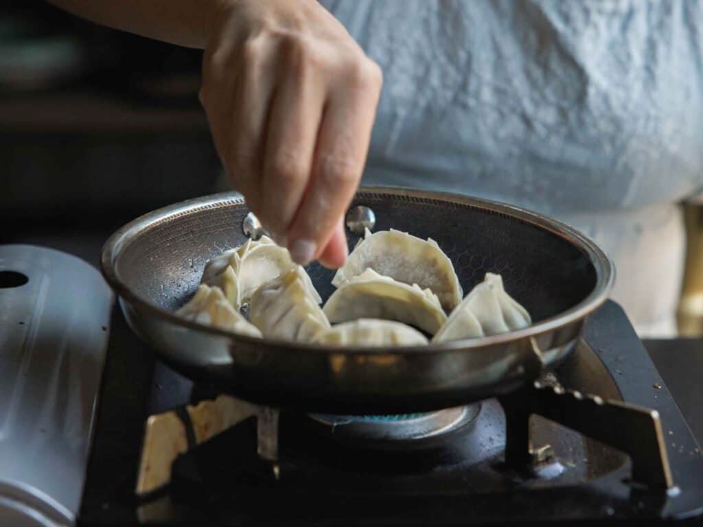 Homemade Vegan Dumplings Recipe - Kimchi Mandu. 35 adding-potstickers-to-pan