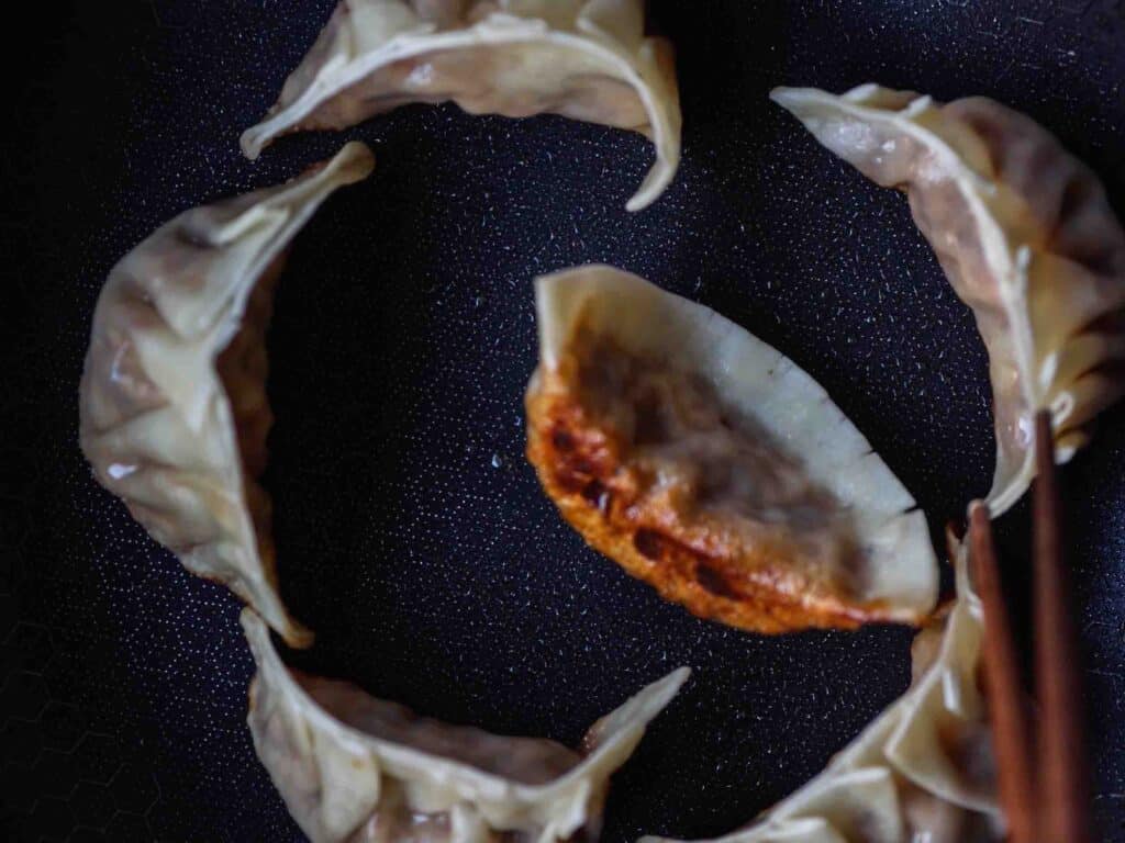 Homemade Vegan Dumplings Recipe - Kimchi Mandu. 38 potstickers-in-pan-cooked-with-brown-bottoms