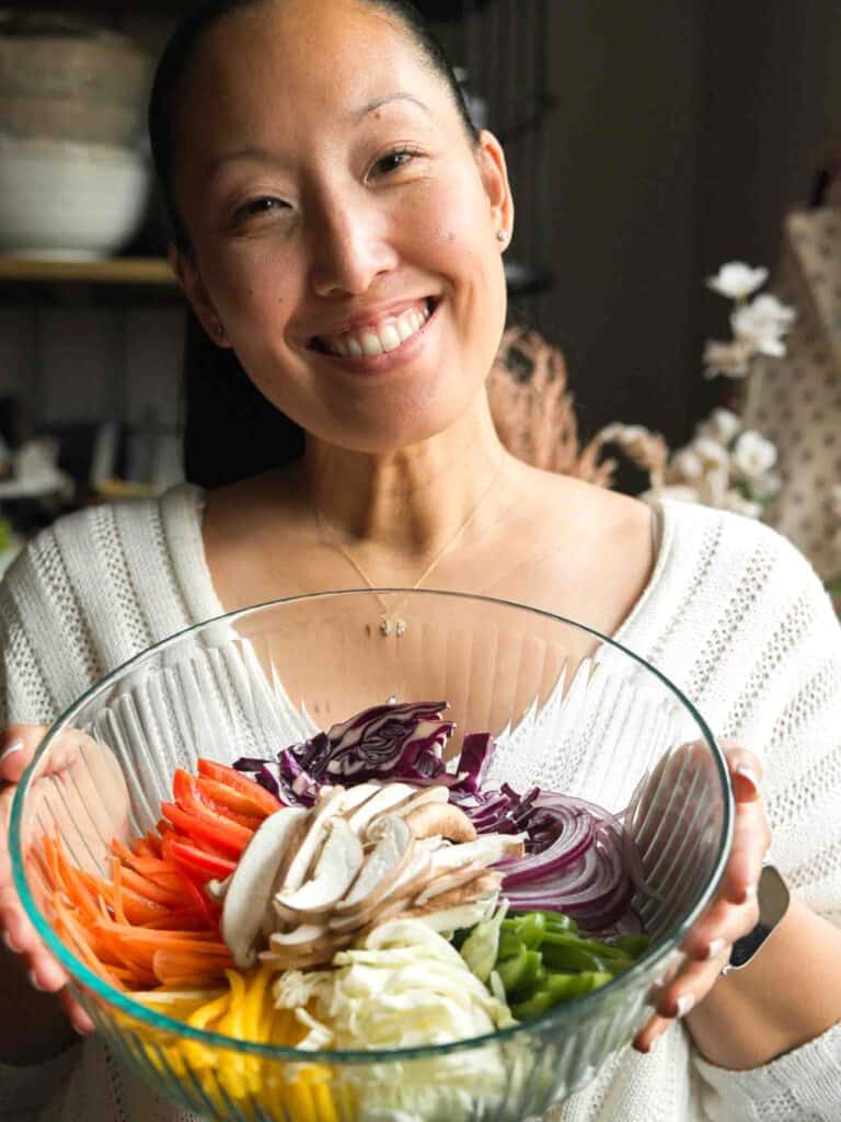 Healthy And Easy Vegan Japchae (Korean Glass Noodles). 3 woman holding bowl of julienned vegetables for vegan japchae