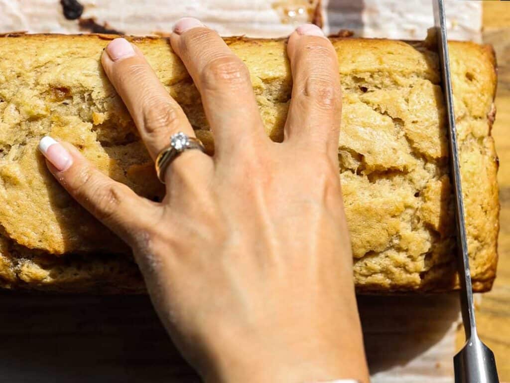 The BEST and FULLY VETTED Vegan Banana Bread Recipe. 1 close-up-top-down-view-of-cutting-vegan-banana-bread
