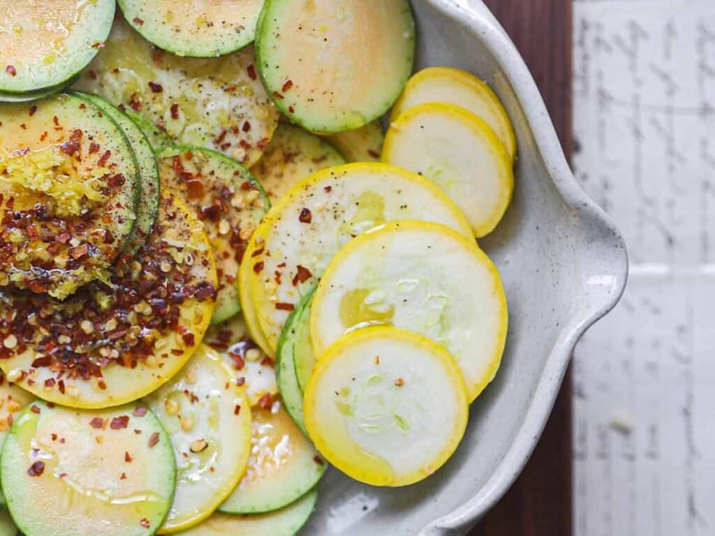 30-Minute Easy Cream Cheese Zucchini Tart (Vegan). 14 close-up-of-squash-rounds-with-chili-flakes-and-lemon-zest-and-olive-oil.