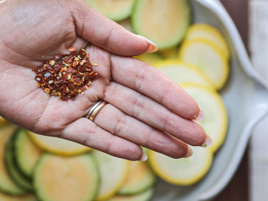 30-Minute Easy Cream Cheese Zucchini Tart (Vegan). 6 ed-chili-flakes-in-palm-of-hand