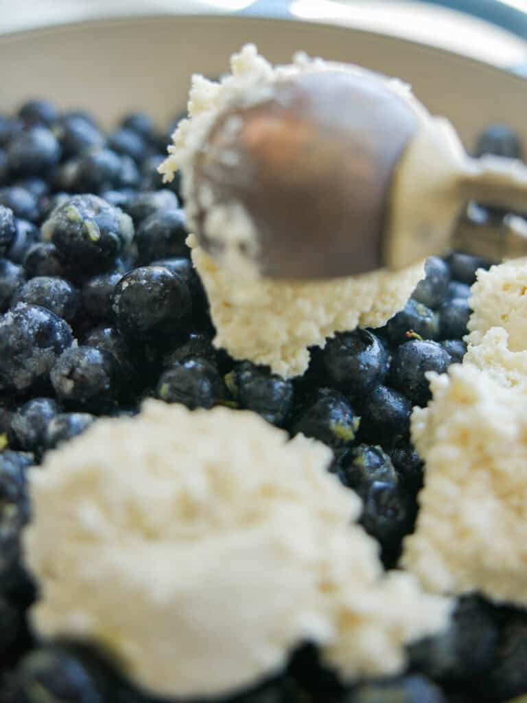 Easy Vegan Blueberry Cobbler (Gluten-Free Option!) 16 scooping-biscuit-batter-over-blueberries