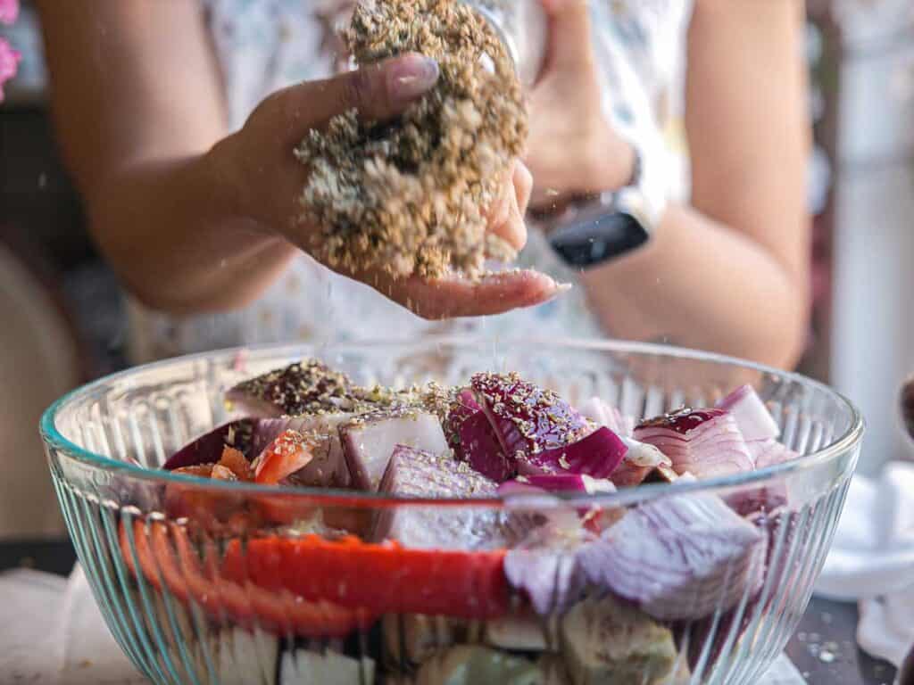 DELICIOUS Hi-Protein Vegan Mediterranean Toast Recipe. 6 adding-dried-oregano-to-bowl-of-vegetables