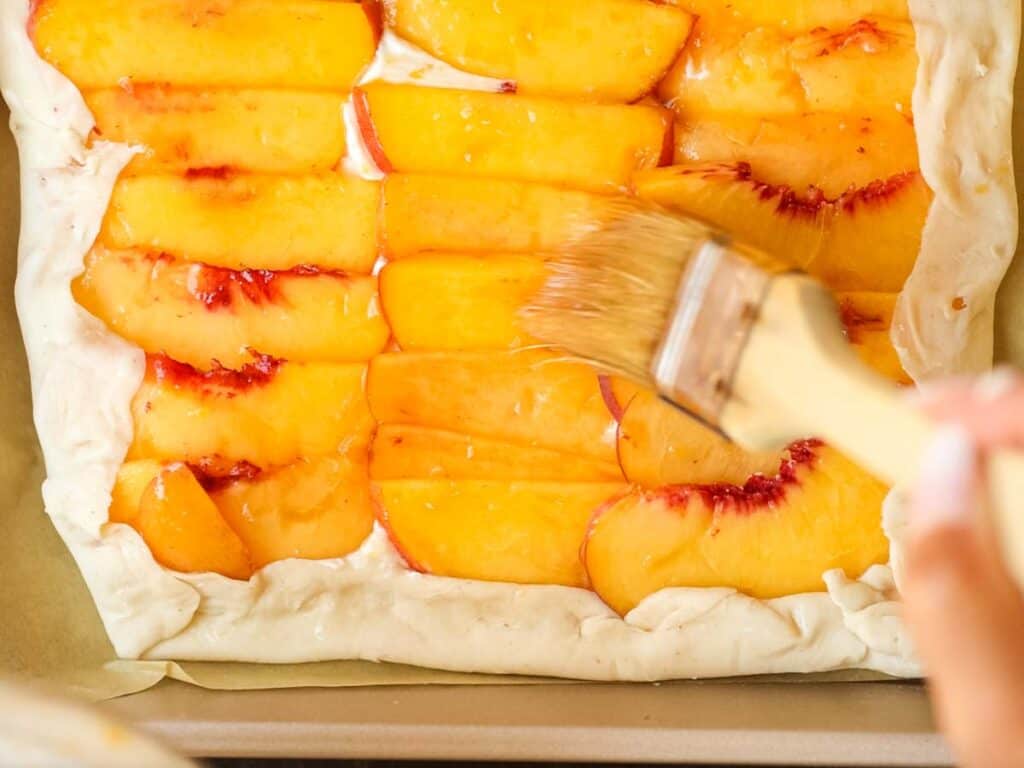 6-Ingredient Easy Cream Cheese Peach Galette Recipe. 20 brushing-glaze-on-peaches-for-peach-galette
