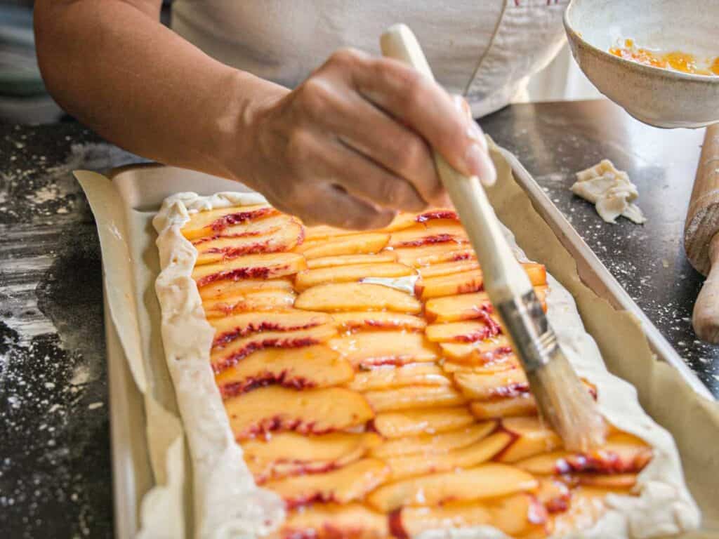 6-Ingredient Easy Cream Cheese Peach Galette Recipe. 19 brushing-peaches-with-glaze-for-peach-galette