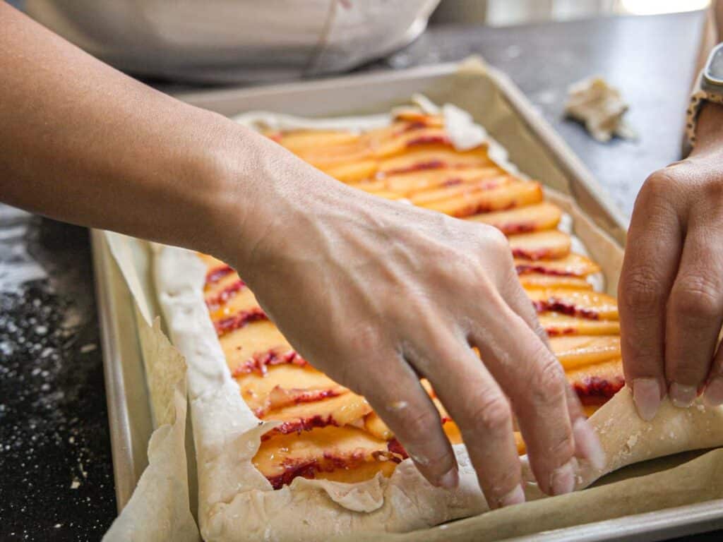 6-Ingredient Easy Cream Cheese Peach Galette Recipe. 18 folding-galette-pastry-over-peaches