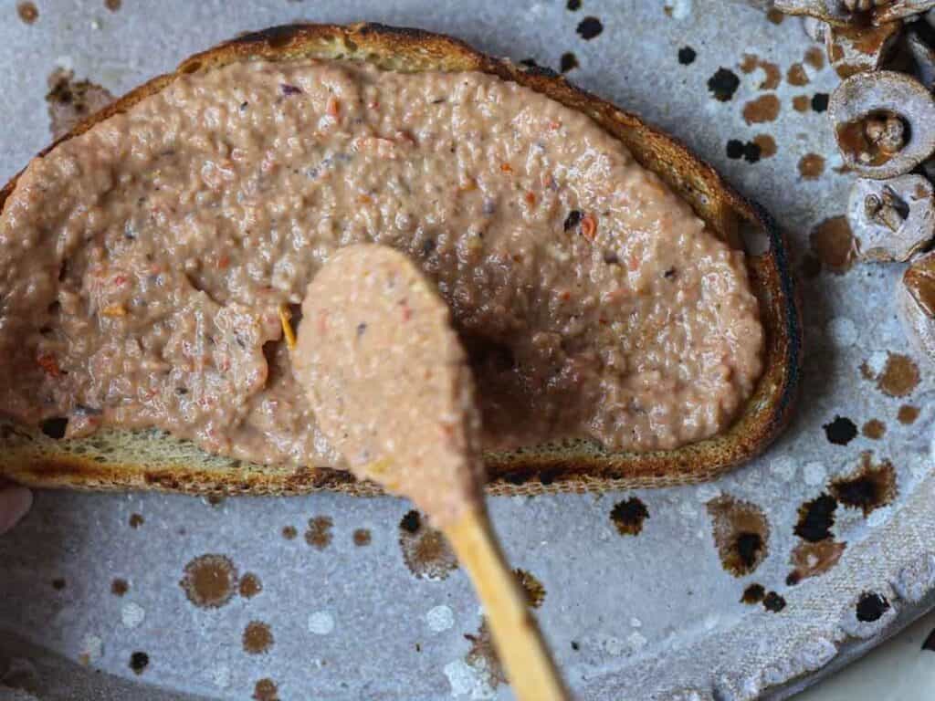 DELICIOUS Hi-Protein Vegan Mediterranean Toast Recipe. 12 spreading-sauce-onto-toast