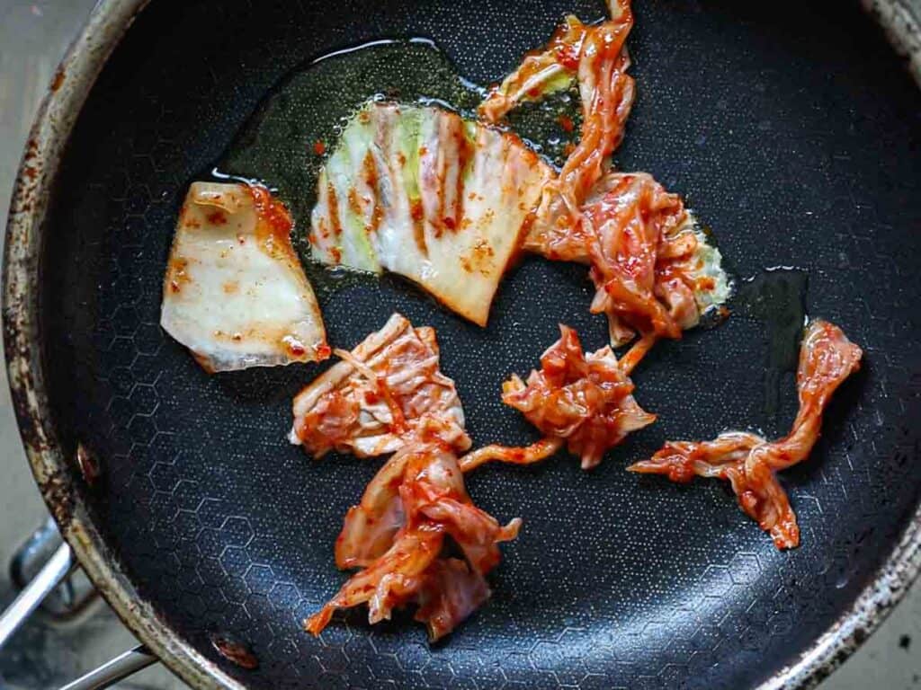 Stunning Vegan Bindaetteok: Korean Mung Bean Pancakes. 9 adding-kimchi-to-pan-before-adding-bindaetteok-batter