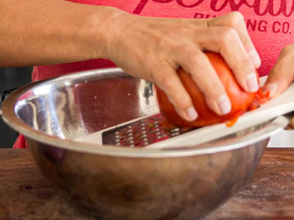 10-Minute Easy Bread Salad Recipe - Peach Panzanella. 9 grating-tomato-into-bowl