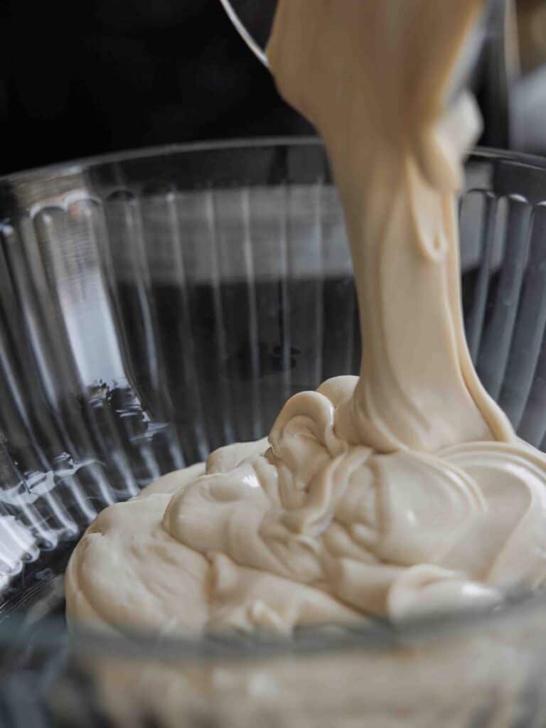 Super Easy and DELICIOUS Vegan Biscoff-Misu Recipe. 12 pouring-mascarpone-and-biscoff-buttercream-into-large-bowl-