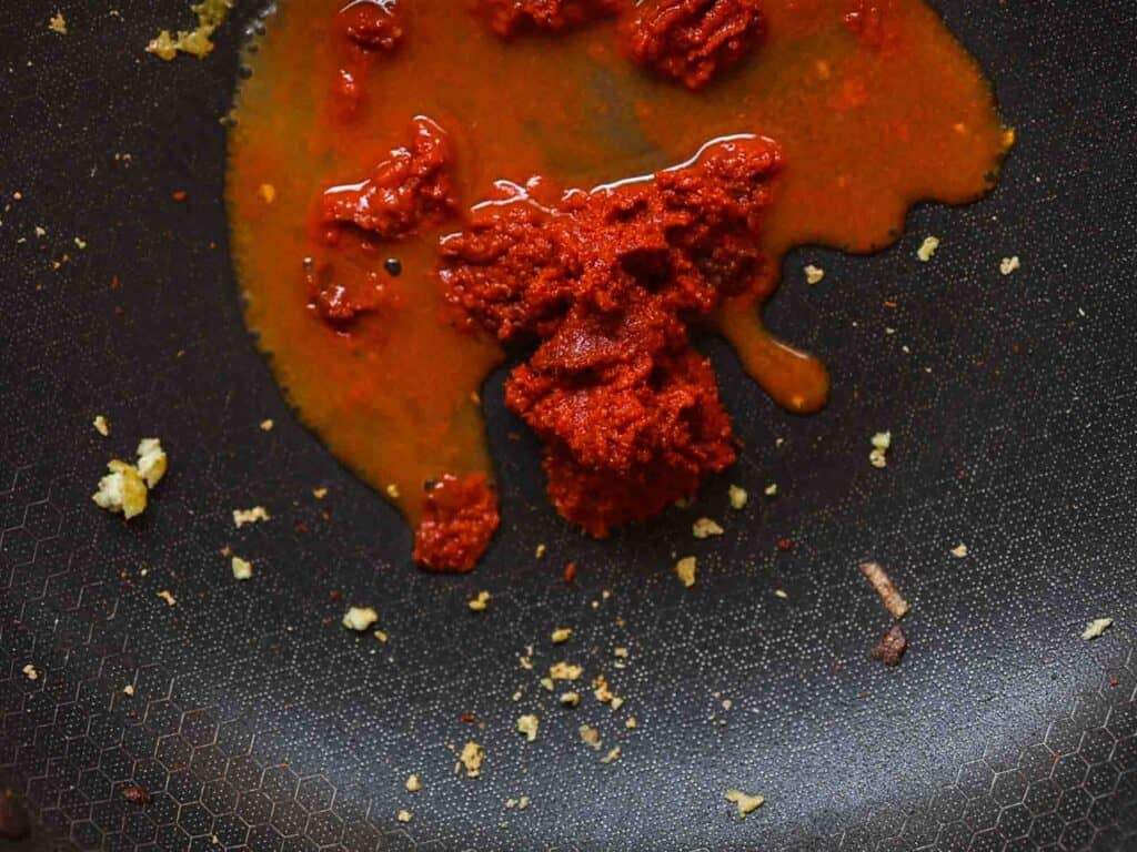 Hi-Protein Delicious Vegan Pumpkin Curry with Tofu. 18 red curry paste cooking in veggie broth