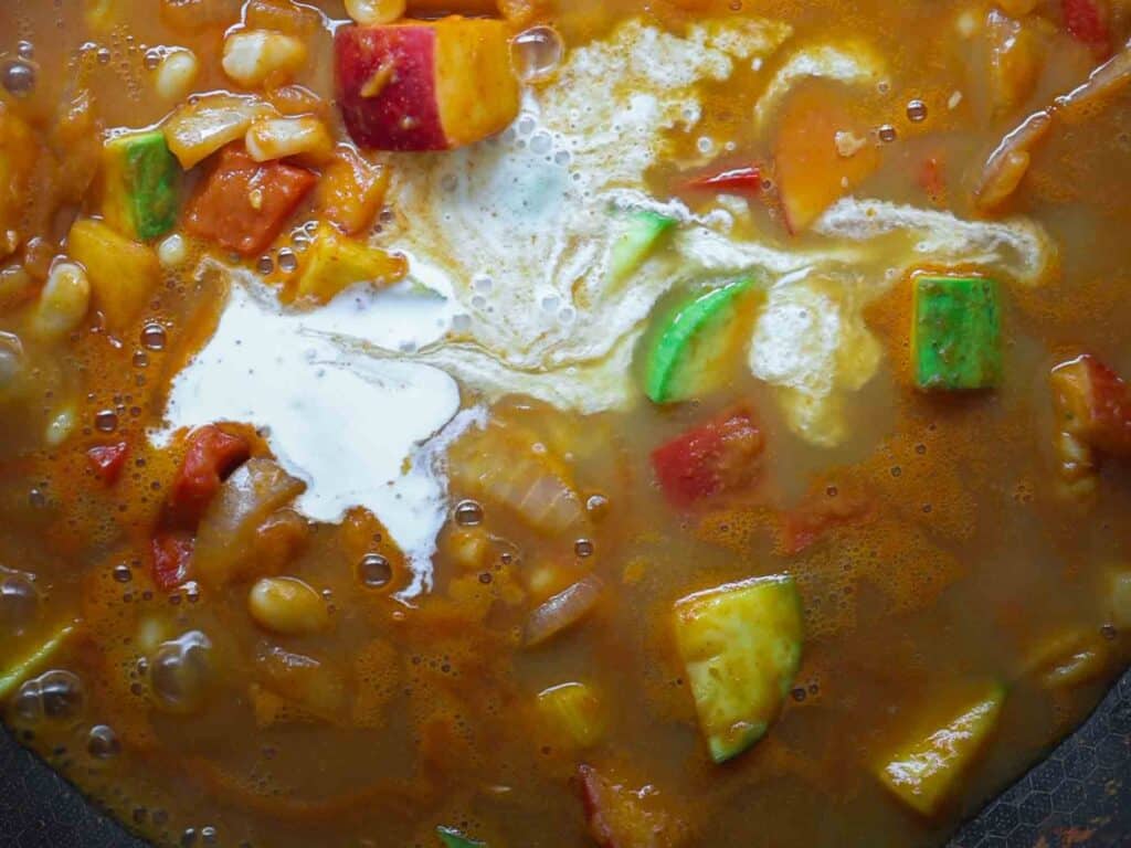 Hi-Protein Delicious Vegan Pumpkin Curry with Tofu. 23 adding coconut milk to pan of pumpkin curry