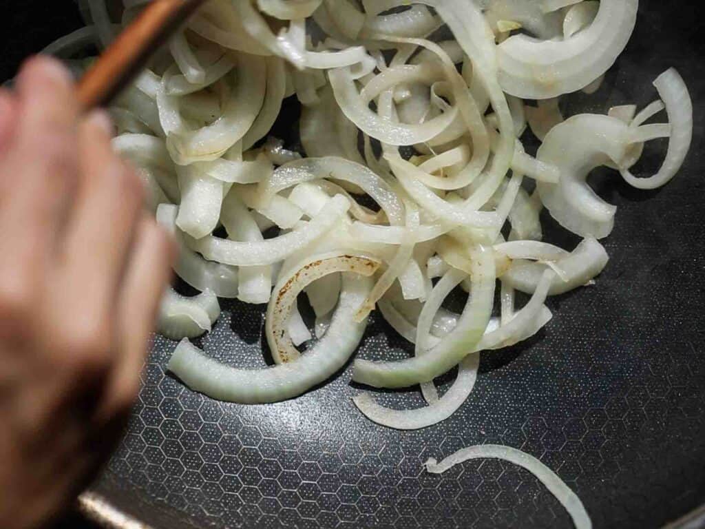 The BEST Apple Cheddar Vegan Grilled Cheese Sandwich. 10 sauteeing onions in pan