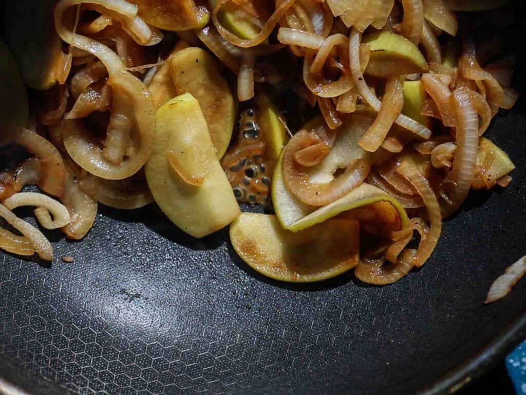 The BEST Apple Cheddar Vegan Grilled Cheese Sandwich. 14 caramelizing apples and onions in pan