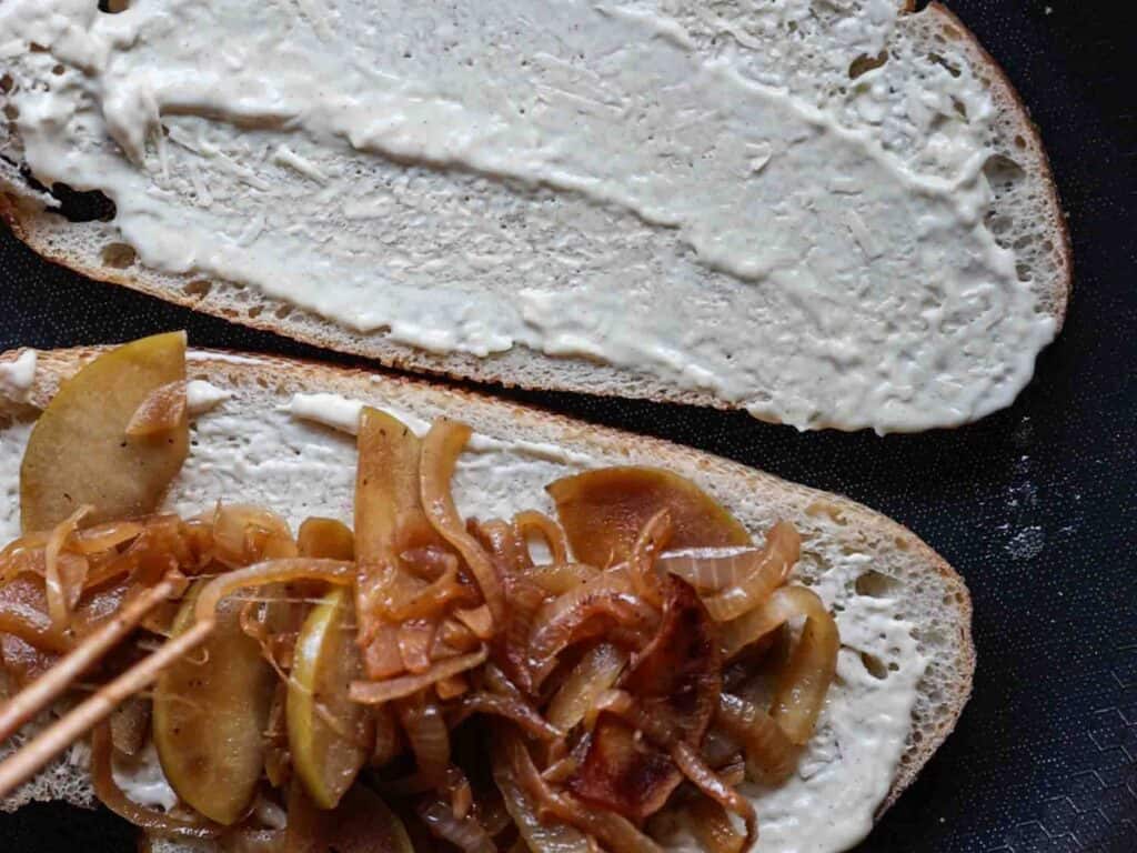 The BEST Apple Cheddar Vegan Grilled Cheese Sandwich. 20 adding apple onion mixture to bread on pan