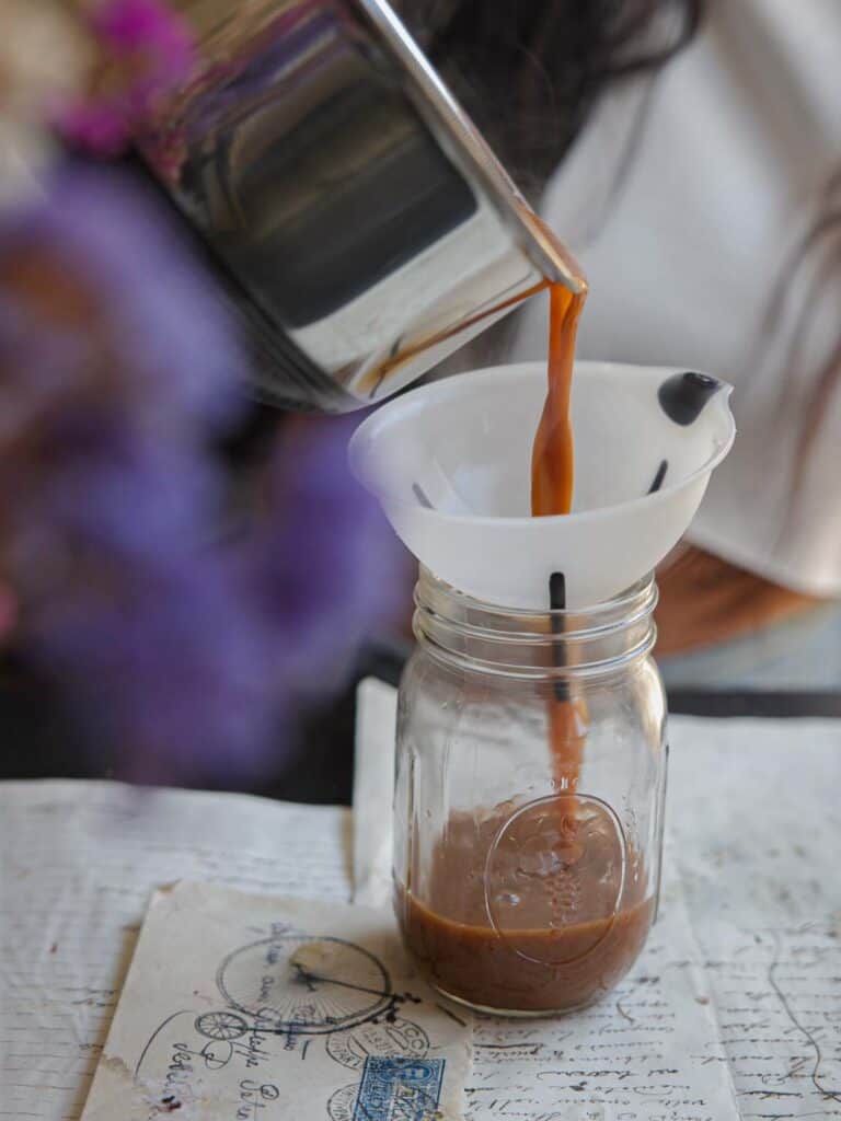 Easy Vegan Pumpkin Spice Syrup (Starbucks Copycat!). 12 pouring vegan pumpkin spice syrup into funnel and mason jar