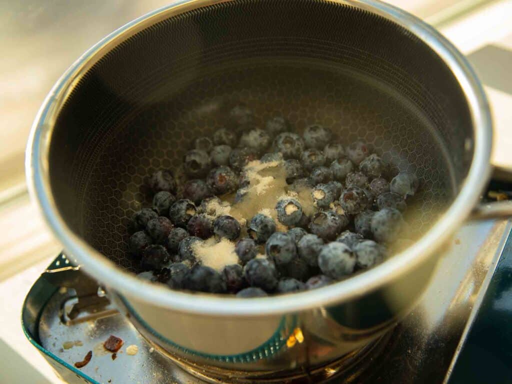 30-Minute Fluffy and Delicious Vegan Lemon Ricotta Pancakes. 6 blueberries in saucepot with sugar