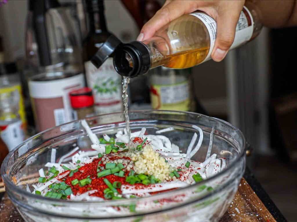 Easy & Spicy Korean Radish Salad - Musaengchae Recipe. 16 adding rice vinegar to julienned radish
