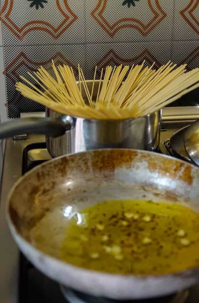 Spaghetti Aglio e Olio: The PERFECT 6-Ingredient Pasta Recipe. 12 adding pasta to pasta water while oil continues to infuse