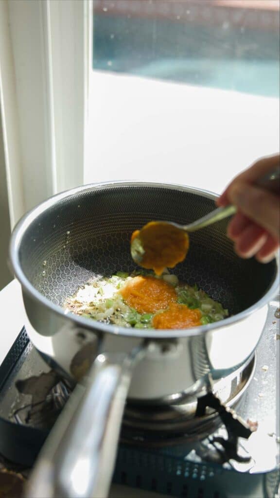 Easy Creamy and Spicy Pumpkin Ramen Recipe (Vegan). 16 adding pumpkin puree to pot of broth
