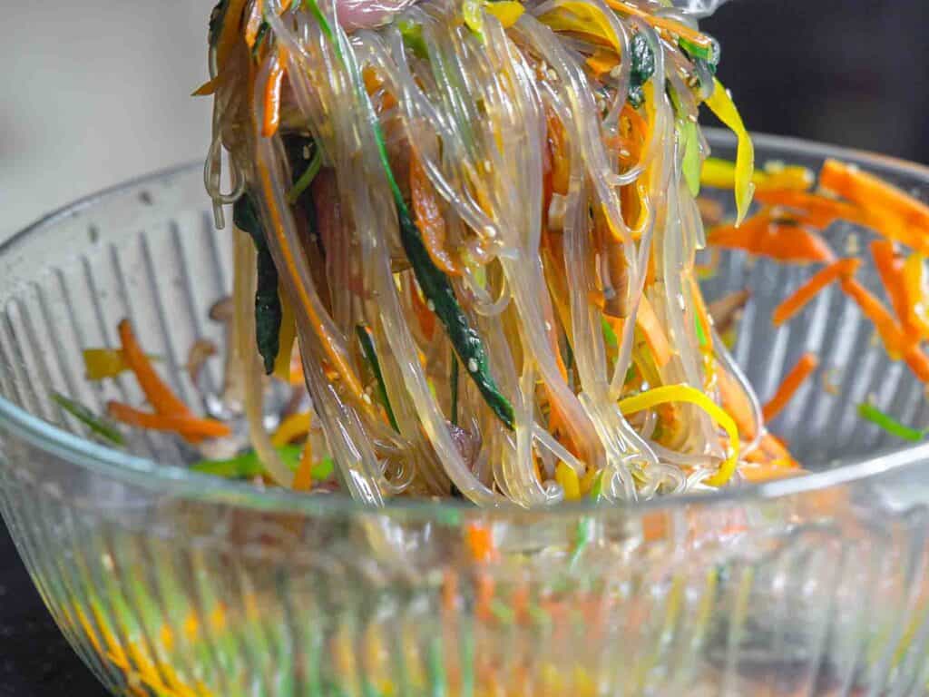 My Mom's Easy Vegetarian Japchae (Glass Noodles). 3 grabbing handful of vegetarian japchae