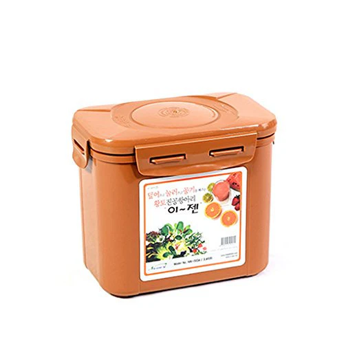 The Korean Vegan's 2025 VEGAN Holiday Gift GUIDE. 19 A tan kimchi container with a lid and handle features a label adorned with colorful fruits and vegetables.